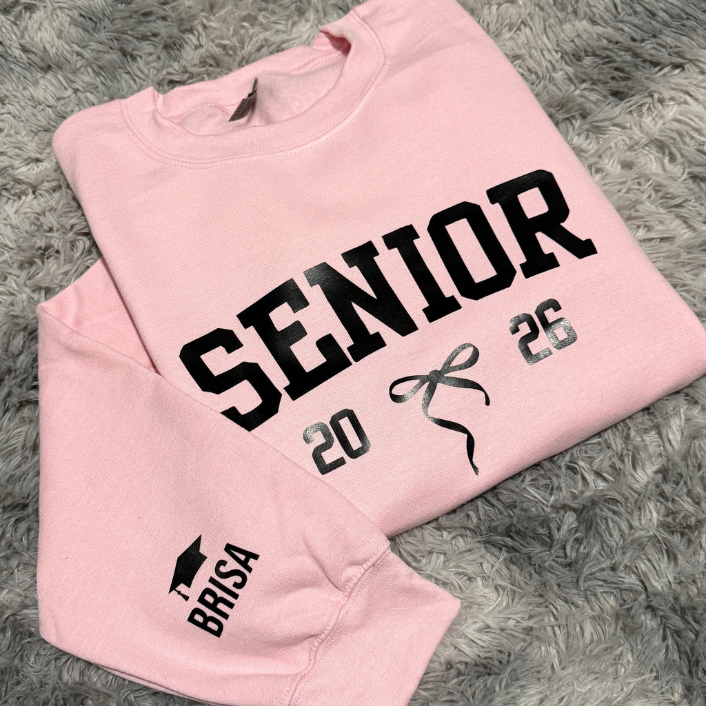 Pink sweatshirt with 'Senior 2025' text on a gray textured background